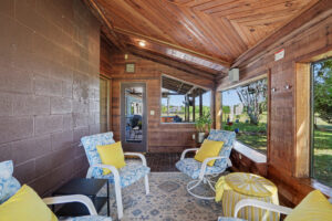 Spacious covered patio with hot tub, wood deck, and scenic backyard views in Philomath, Oregon ranch home for sale.